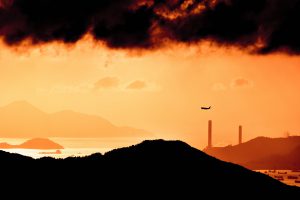 Photo of aeroplane on red sky and with clouds above