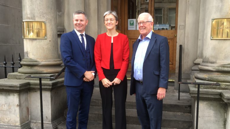 Three people smiling outside the RSE