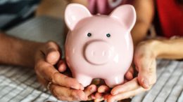 Photo of two people holding a piggy bank