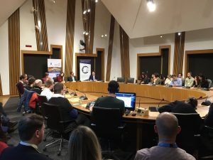 Photo of event with people sitting around a committee room table in the Scottish Parliament