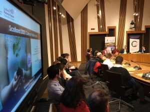 Photo of event with people sitting around a committee room table in the Scottish Parliament