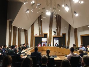 Photo of event with people sitting around a committee room table in the Scottish Parliament