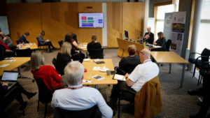 Room at the Scottish Parliament with people listening to Olli-Pekka Heinonen