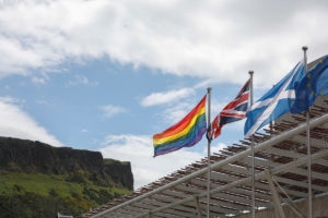 Front of Scottish Parliament building with flags flying - Pride, UK, Scotland and EU