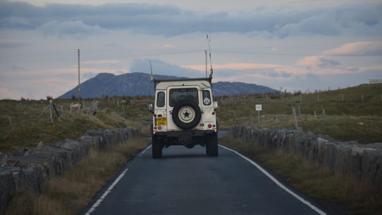 Range-rover driving into distance toward mountain