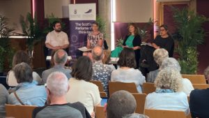 Panel of speakers in a room at the Scottish Parliament