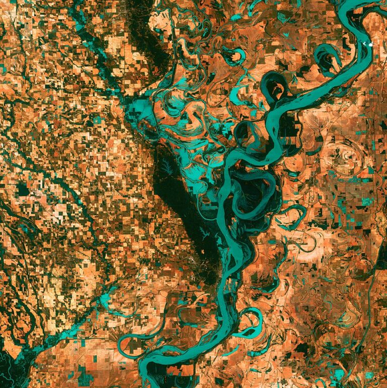 Small, blocky shapes of towns, fields, and pastures surround the graceful swirls and whorls of the Mississippi River. Countless oxbow lakes and cutoffs accompany the meandering river.