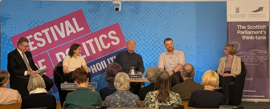 Panel members infront of an audience at the Festival of Politics