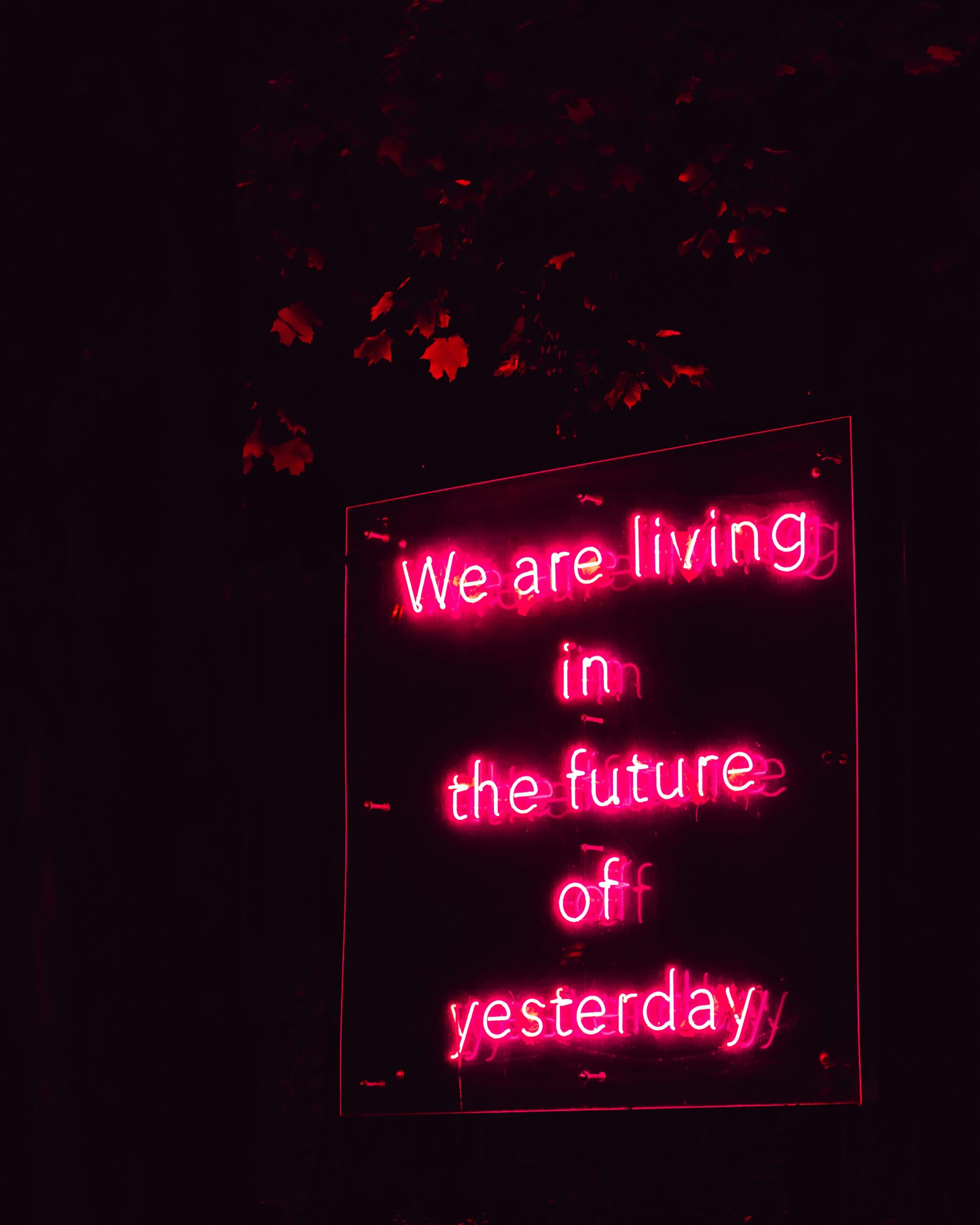 Pink neon sign which says: We are living in the future of yesterday